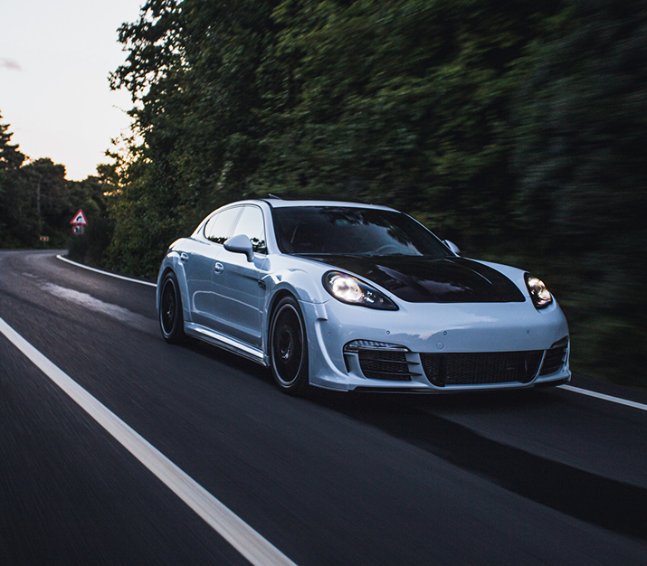 White sports car driving on a forest road